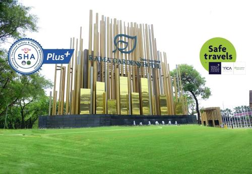 a large building in a field of green grass at Rama Gardens Hotel Bangkok in Bangkok