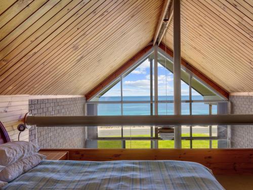 Bett in einem Zimmer mit einem großen Fenster in der Unterkunft South Beach House 2 11 Gold Coast Drive in Carrickalinga