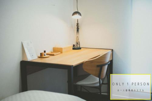 een bureau in een kamer met een lamp erop bij RAK KIYOMIZU - 1人旅専用hostel in Kyoto