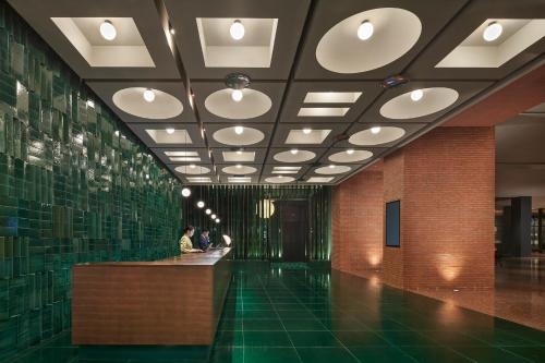 a lobby with a green floor and a ceiling with lights at TAOXICHUAN Hotel in Jingdezhen