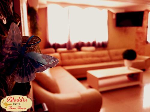 a living room with a couch and a table at Aladdin Hotel Beer Sheva in Beer Sheva