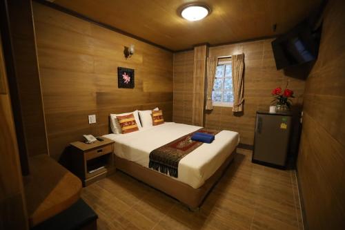 a bedroom with a large bed and a television at Thai Cozy House in Bangkok
