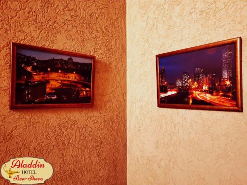 two pictures on the wall of a building at Aladdin Hotel Beer Sheva in Beer Sheva