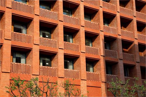 a red brick building with lots of windows at Hyatt Place Jingdezhen Taoxichuan in Jingdezhen