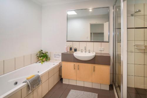 a bathroom with a sink and a tub and a mirror at Villa on Fearn in Margaret River Town