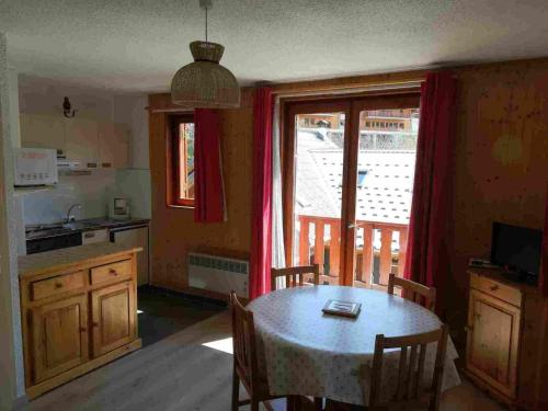 eine Küche und ein Esszimmer mit einem Tisch und einem Fenster in der Unterkunft Studio Valloire, 1 pièce, 5 personnes - FR-1-263-449 in Valloire