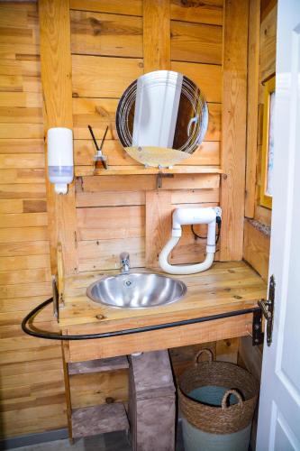 une salle de bain avec un lavabo et un miroir dans l'établissement La yourte de Nîmes, sauna, spa , jacuzzi piscine et aire de jeux privatif, à Caveirac