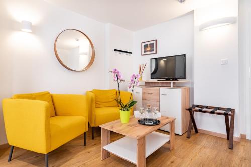 a living room with a yellow couch and a table at Penzion Quest in Loket