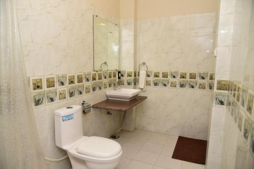 a white bathroom with a toilet and a sink at The Q Villa, Udaipur in Udaipur