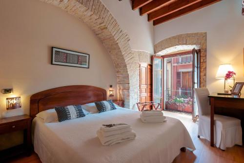 a bedroom with a bed with towels on it at Sa Domu Cheta in Cagliari