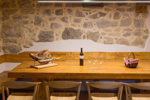 a wooden table with a bottle of wine and chairs at Luxury Jerini Estate in Krk