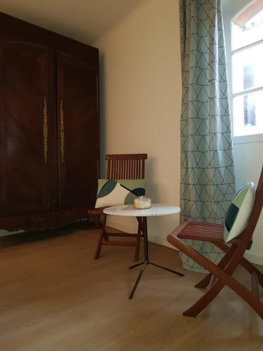 a living room with a table and a chair at Maison de ville Forum Julii in Fréjus