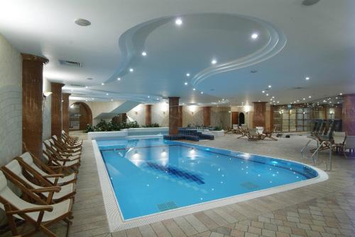 a large swimming pool in a hotel with a ceiling at Gai Beach Hotel in Tiberias