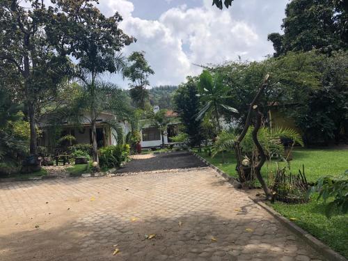 a house with a brick driveway in front of a yard at Kivu Beach Garden in Gisenyi