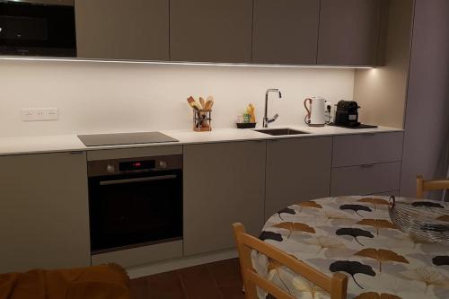 a kitchen with a table and a stove and a counter top at Maison de ville Forum Julii in Fréjus
