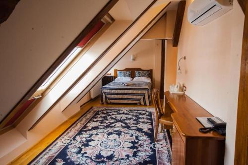 an attic room with a bed and a rug at Casa Wagner in Braşov