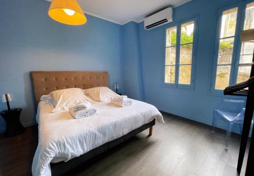 um quarto azul com uma cama com duas toalhas em La Petite Fontaine em Saint-Émilion