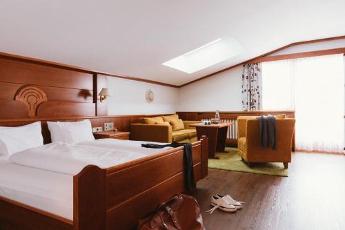 a hotel room with a bed and a living room at Gartenhotel Linde 4 Sterne Superior in Ried im Oberinntal