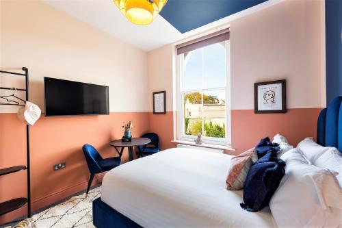 a bedroom with a bed and a tv and a window at Clifton House I Free Private Parking in Bristol