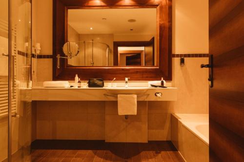 a bathroom with a sink and a mirror at Gartenhotel Linde 4 Sterne Superior in Ried im Oberinntal
