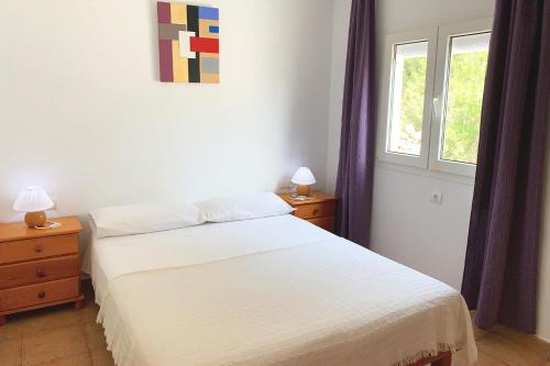 a bedroom with a white bed and two windows at La Casita Yolanda, ideal parejas - Formentera Natural in Sant Ferran de Ses Roques