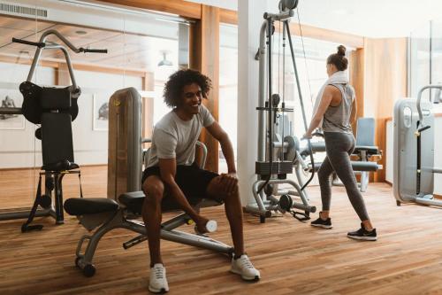 a man sitting on a exercise bike in a gym at Gartenhotel Linde 4 Sterne Superior in Ried im Oberinntal