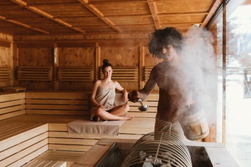 a man and a woman in a sauna at Gartenhotel Linde 4 Sterne Superior in Ried im Oberinntal