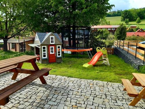 un parco giochi con un set di giochi e una casetta per bambini di Penzion Pod Sudem a Lázně Libverda