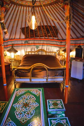 une chambre avec un lit dans une yourte dans l'établissement La yourte de Nîmes, sauna, spa , jacuzzi piscine et aire de jeux privatif, à Caveirac