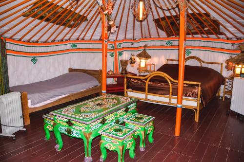 una habitación con 2 camas y una mesa en una yurta en La yourte de Nîmes, spa , jacuzzi chalet logement insolite en Caveirac
