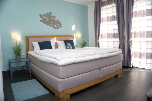 ein Schlafzimmer mit einem großen Bett mit blauen Wänden in der Unterkunft strandnah, Wintergarten, gratis Nutzung vom AHOI Erlebnisbad und Sauna in Sellin - Strandhaus Mönchgut FeWo08 in Lobbe