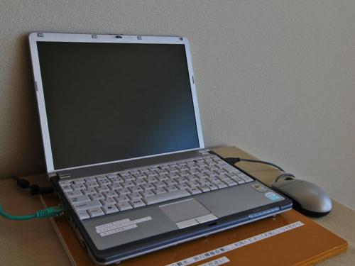 a laptop computer sitting on a table with a mouse at Ikkyu -Seaside Hotel- in Tsuruoka
