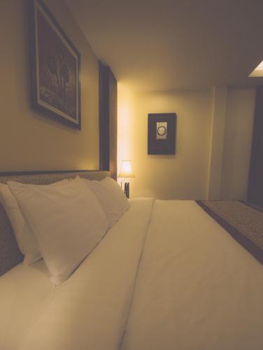 a large white bed in a room with a lamp at Salana Boutique Hotel in Vientiane