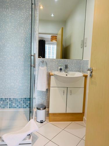 a bathroom with a sink and a shower at Woking Town Centre - Parking Included by Deilamy Homes in Woking