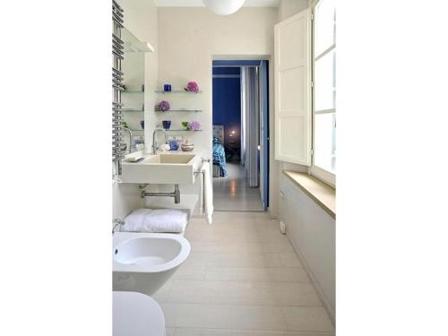 a white bathroom with a sink and a toilet at Beach Front Bibbona in Marina di Bibbona