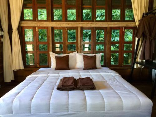 a large white bed with two towels on it at Phayam Valley Homestay in Ko Phayam