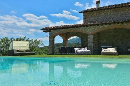a swimming pool in front of a stone building at Villa Le Croci Firenze in Bovecchio