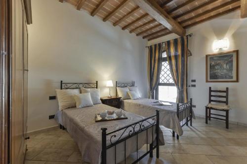 a bedroom with two beds and a table and a chair at Villa Le Croci Firenze in Bovecchio