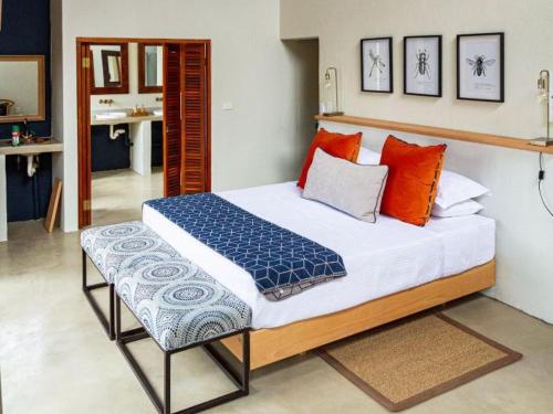 a bedroom with a large bed with orange and blue pillows at Eclectic Safari Lodge in Mabula