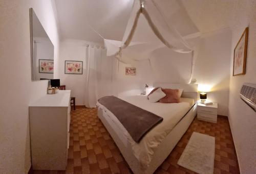 una camera bianca con un grande letto e una scrivania di Villa Lido with pool and garden a Lido Marini
