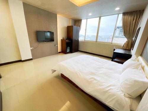 um quarto com uma cama grande e uma televisão em 花蓮花見你民宿 em Hualien