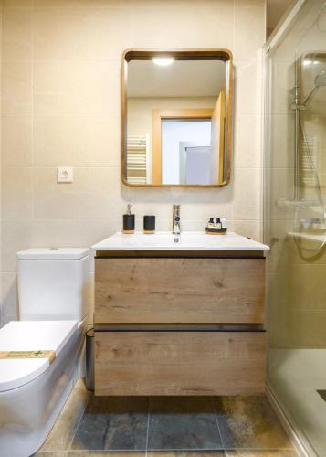 a bathroom with a sink and a mirror at Alojamiento Mundarrey Bïescas in Biescas