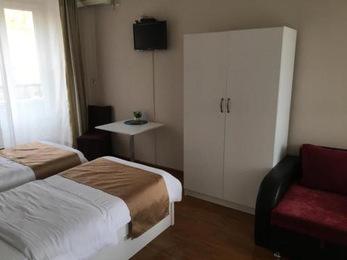 a bedroom with a bed and a cabinet and a chair at Hotel Nata in Tbilisi City