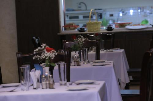 a table with white table cloths and flowers on it at Daisy Hotel in Addis Ababa