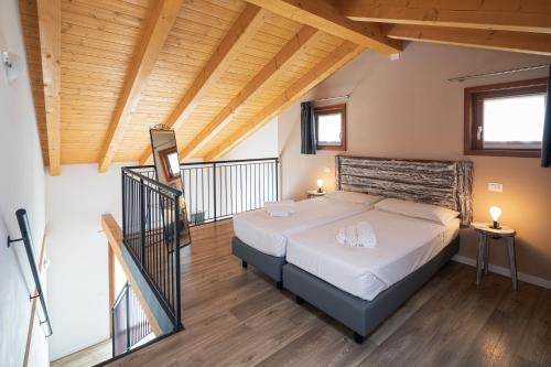 una camera con letto in una stanza con soffitti in legno di Agriturismo ai Due Leoni a Aquiléia