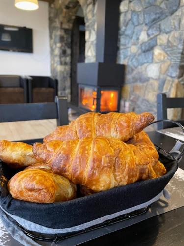 a pan filled with bread and croissants in front of a fireplace at Blyzhche Neba in Yablunytsya