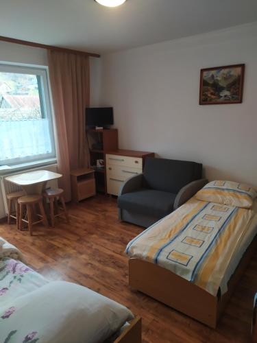 a bedroom with a bed and a couch and a chair at Pokoje gościnne u Zosi Krościenko in Krościenko