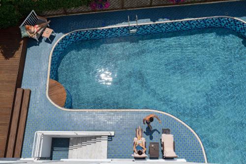 una piscina con 2 sillas y un nadador en ella en A for Art Hotel en Limenas
