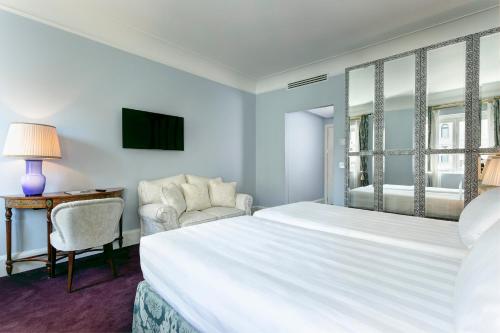 a bedroom with a large white bed and a desk at Grand Hotel Duchi d'Aosta in Trieste