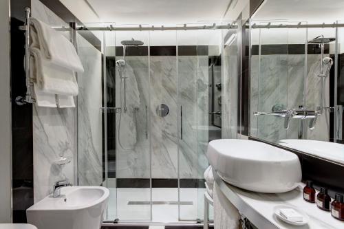 a bathroom with a shower and a sink and a toilet at Grand Hotel Duchi d'Aosta in Trieste
